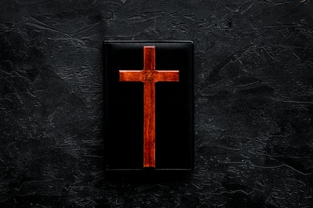 Farewell ceremony, funeral concept. Wooden cross on Bible on black background top view copy spaceの写真素材