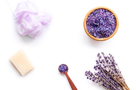 Spa set with lavender spa salt. Purple spa salt near dry lavender branches and washcloth on white background top view.の写真素材