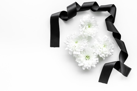 Funeral symbols concept. White flower near black ribbon on white backgroundの写真素材