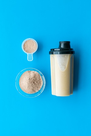 protein cocktail with powder for sport nutrition set l on blue background top view mock-upの写真素材