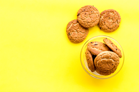Homemade oatmeal cookies in glass bowl on yellow background top view copy spaceの写真素材