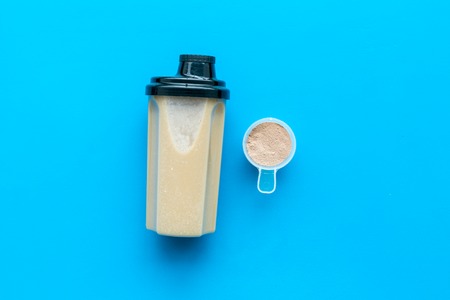 protein cocktail with powder for sport nutrition set l on blue background top view mock-upの写真素材