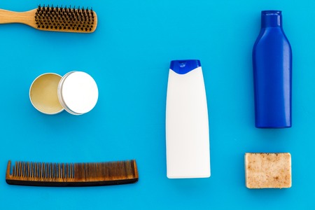 Barber workspace with equipment. Shampoo bottle and comb on light blue table background top view space for textの写真素材