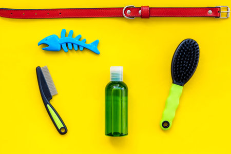 Care about pet with brushes and grooming equipment on yellow background top viewの写真素材