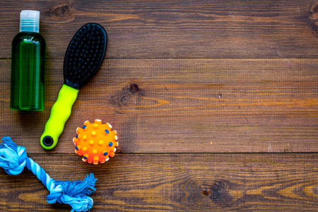 Pet accessories for care and training. Brushes and toys on wooden background top view mock-up.の写真素材