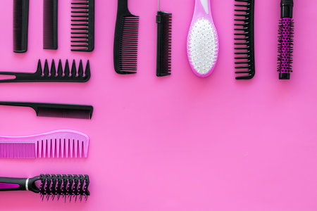 Set of professional hairdresser tools with combs on pink background top view mockup