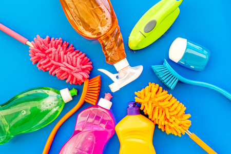 Housecleaning with detergents, soap, cleaners and brush in plastic bottles on blue desk background top view mockupの写真素材