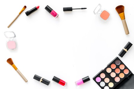 Visagiste desk with decorative cosmetics: eyeshadows, lipstick, brush on white background top view space for textの写真素材