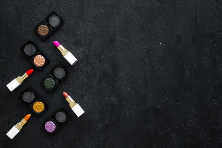 Female desk with decorative cosmetics for make up on dark background top view mockupの写真素材