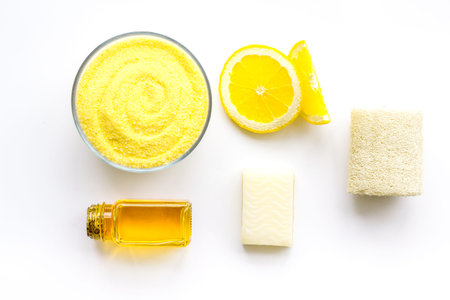 Lemon spa salt and spa accessories like soap, loofah, spa oil on white background top view.の写真素材