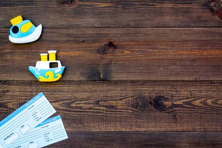 Accessories for traveling with children, tickets and toys on wooden desk background top view mock-upの写真素材