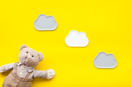 Baby care with craft toys for newborn. Teddy bear. Yellow desk background top viewの写真素材