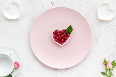 Simple color table setting for celebration with wineberry, white plates and wineberry on white table background top view.の写真素材