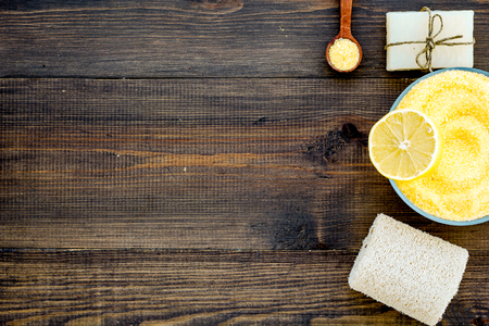 Lemon spa salt and spa accessories like soap, loofah, spa oil on dark wooden background top view.の写真素材