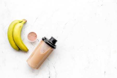 Sport nutrition set with protein powder for cocktail and fruit on white deskの写真素材