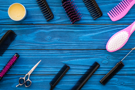 Female hairdresser desk with accessories and combs on blue wooden background top view mock-up.の写真素材