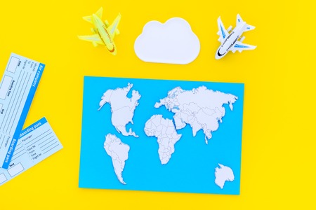 accessories for treveling with children, tickets, map and toys on yellow background top viewの写真素材