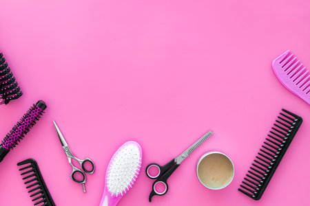 professional accessories of hairdresser on work desk pink background top view space for text