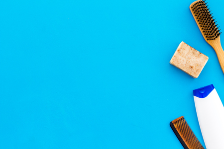 barber workspace with equipment. Shampoo bottle and comb on light blue background top view space for textの写真素材
