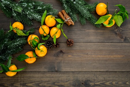 New Year and Christmas Eve with mandarins, fir tree and cinnamon . Citrus winter fruits on wooden background top view space for textの写真素材