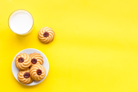 Drink milk with cookies concept. Cup of milk and fresh homemade cookies on yellow background top view space for textの写真素材