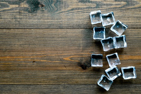 Bar desk with ice cubes on wooden background top view space for textの写真素材