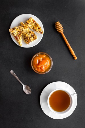Dessert for evening tea. Cup of tea, fresh homemade cookies on black background top viewの写真素材
