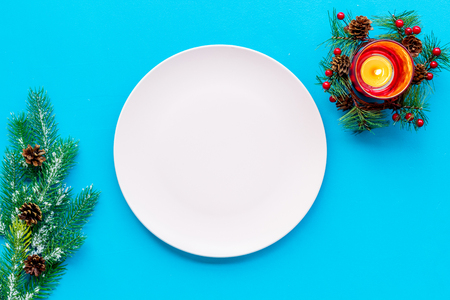 Christmas table setting with gift box and fir tree blue background top view mockupの写真素材