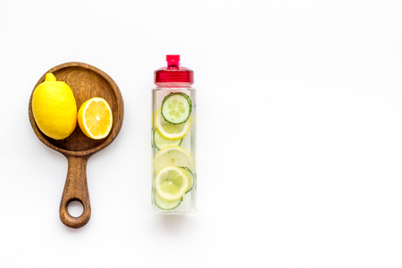 Detox infused water with slices of lemon and cucumber in bottle on white background top view space for textの写真素材