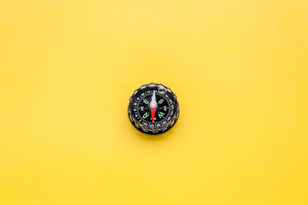 Direction concept with compass on yellow background top view mockup