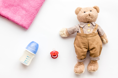Toys for newborn baby set with teddy bear and milk in bottle on white background flat layの写真素材