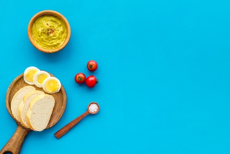 Healthy breakfast. Toasts with vegetables and guacamole on blue background top view space for textの写真素材