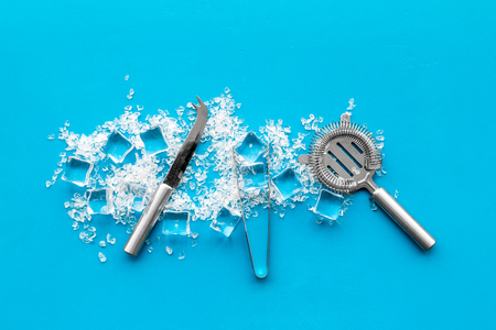 Crashed ice cubes with barman tools on blue kitchen table top view.の写真素材