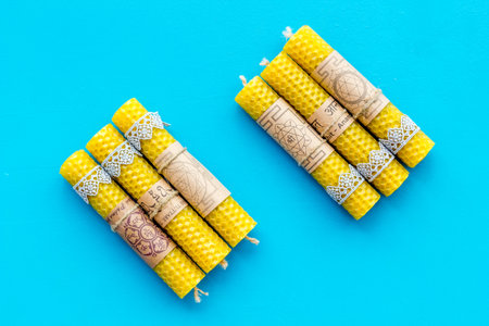 Buddhism. Candles with Yantras and mantras in Sanskrit on blue background top view.