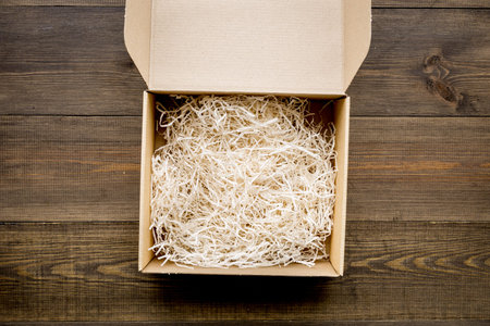 E-commerce. Delivery of goods that was purchased online. Empty cardboard box with cut paper on dark...