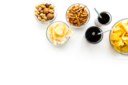 Snacks for TV watching. Chips, nuts, soda, rusks on white background top view copy spaceの写真素材