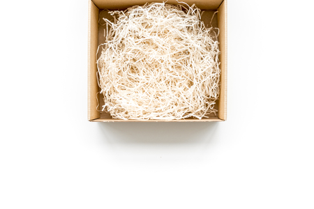 E-commerce. Delivery of goods that was purchased online. Empty cardboard box with cut paper on white background top view copy spaceの写真素材