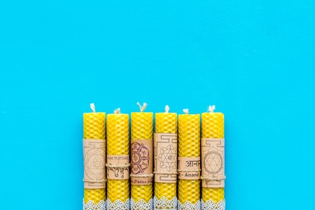 Buddhism. Candles with Yantras and mantras in Sanskrit on blue background top view pattern copy spaceの写真素材