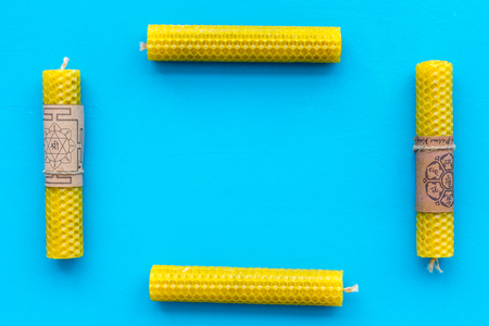 Buddhism. Candles with Yantras and mantras in Sanskrit on blue background top view.の写真素材