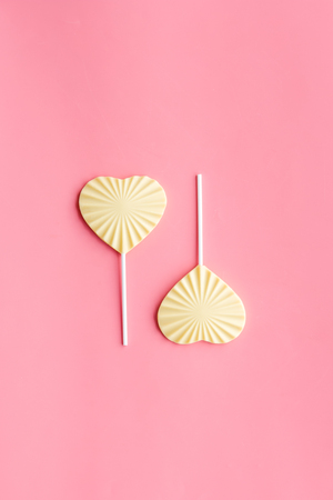 Heart-shaped lollipop for Valentine's day on pink background top view.の写真素材