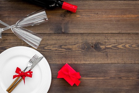 Romantic dinner with wine. Valentine's day. Decorated table, gift box on dark wooden background top view.の写真素材