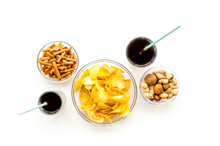 Snacks for TV watching. Chips, nuts, soda, rusks on white background top view.の写真素材