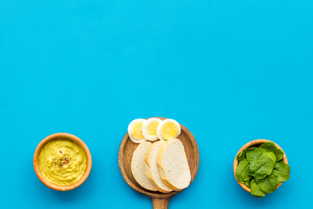Healthy breakfast. Toasts with vegetables and guacamole on blue background top view space for textの写真素材