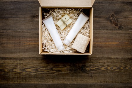 Delivery. Cardboard box with cosmetics on dark wooden background top view space for textの写真素材