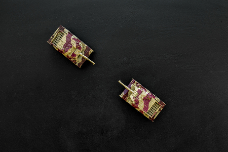 War concept. Tanks toy on black background top view copy spaceの写真素材