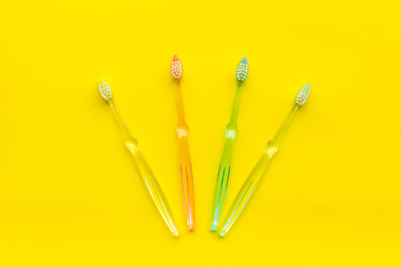 Clean teeth. Plastic toothbrushes on yellow background top view copy spaceの写真素材