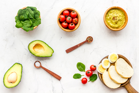 Healthy breakfast. Toasts with vegetables and guacamole on white background top view.の写真素材