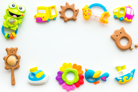 Handmade toys for newborn babies, plastic and wooden rattle on white background top view.の写真素材