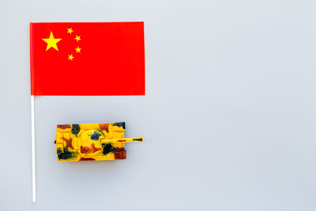 War, military threat, military power concept. China. Tanks toy near Chinese flag on grey background top view copy spaceの写真素材