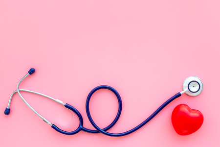 Heart health, health care concept. Stethoscope near rubber heart on pink background top view.の写真素材